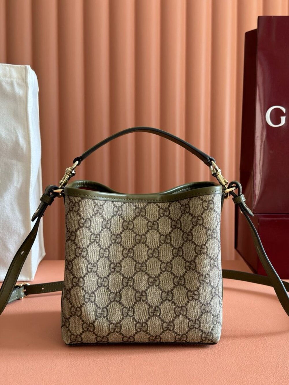 GG Emblem bucket bag crafted in Ancora red embossed GG leather Light gold-toned
